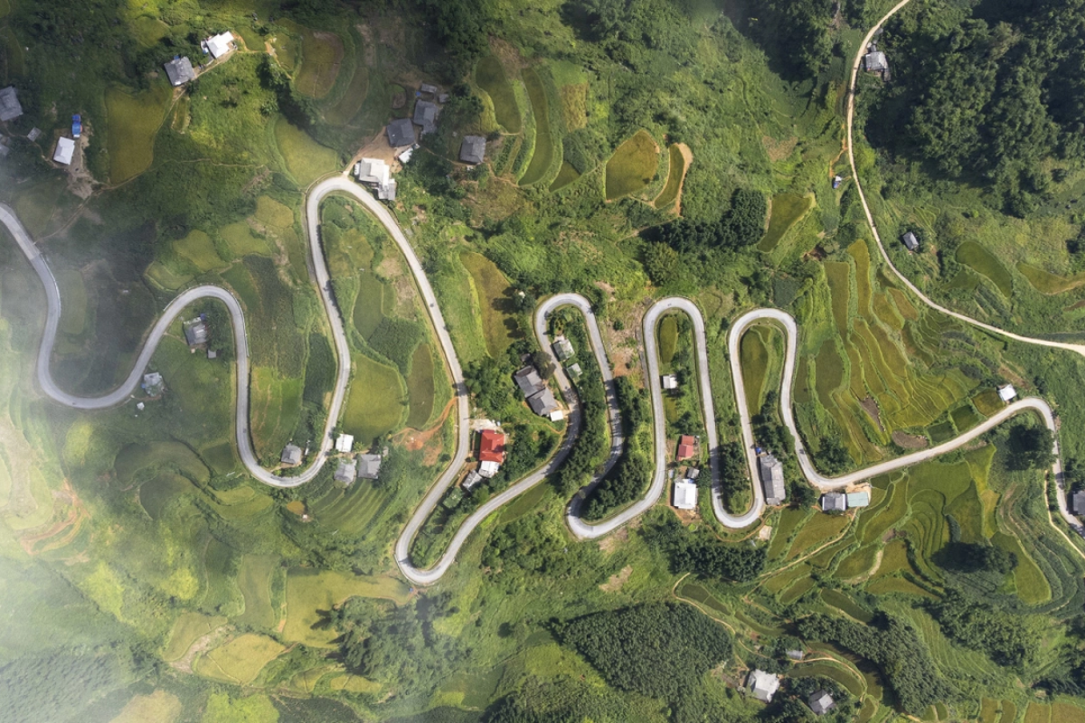 Aerial view capturing all 20 curves of Na Tenh Pass with misty mountains in the background